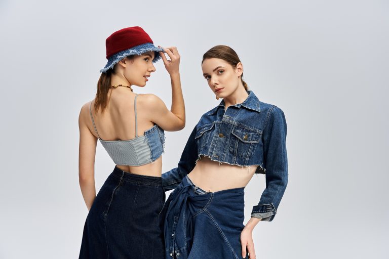 Twin sisters pose elegantly, showcasing their stylish denim outfits and stunning looks.